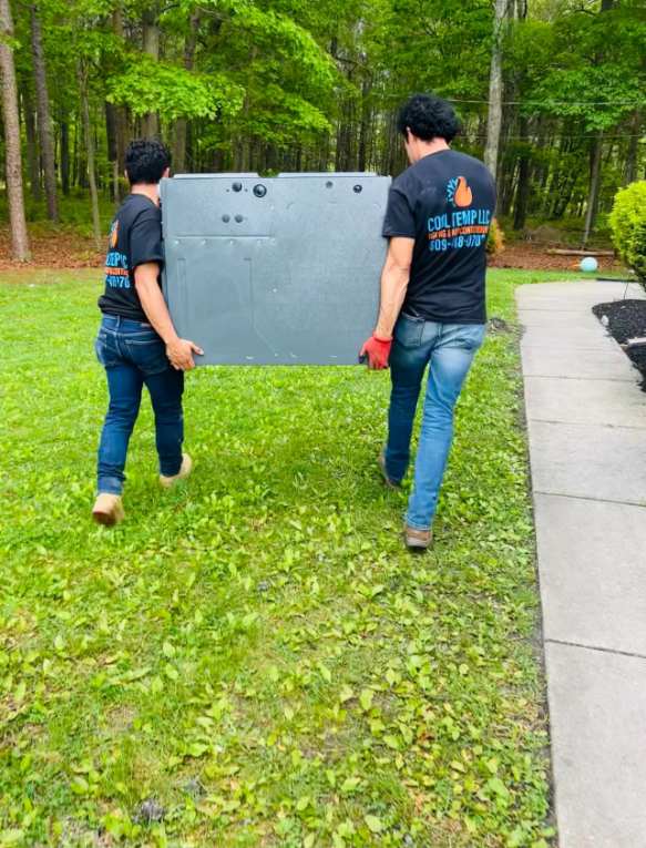 Cool Temp team carrying new HVAC equipment at a Pleasantville job
