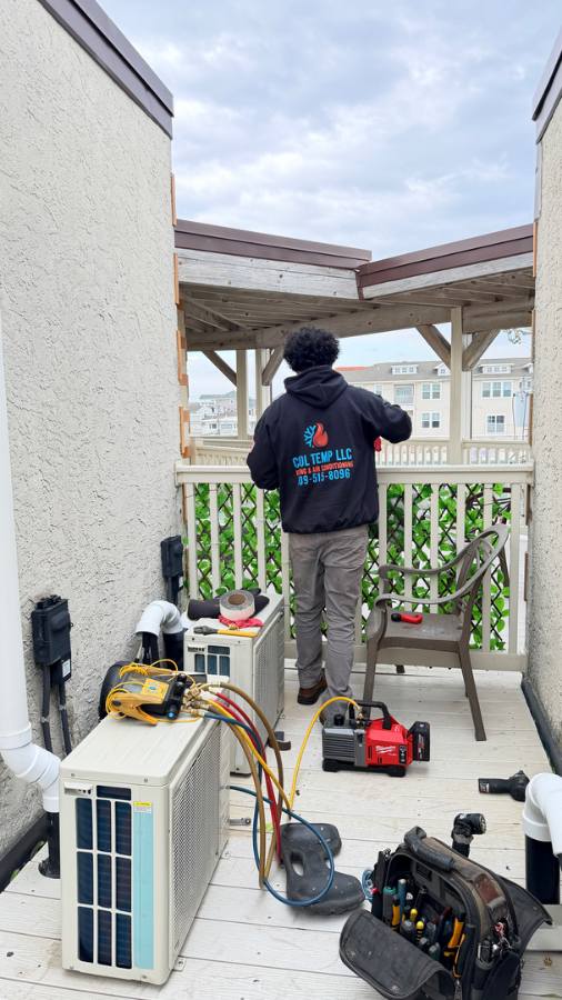 Cool Temp tech repairing porch-mounted HVAC equipment