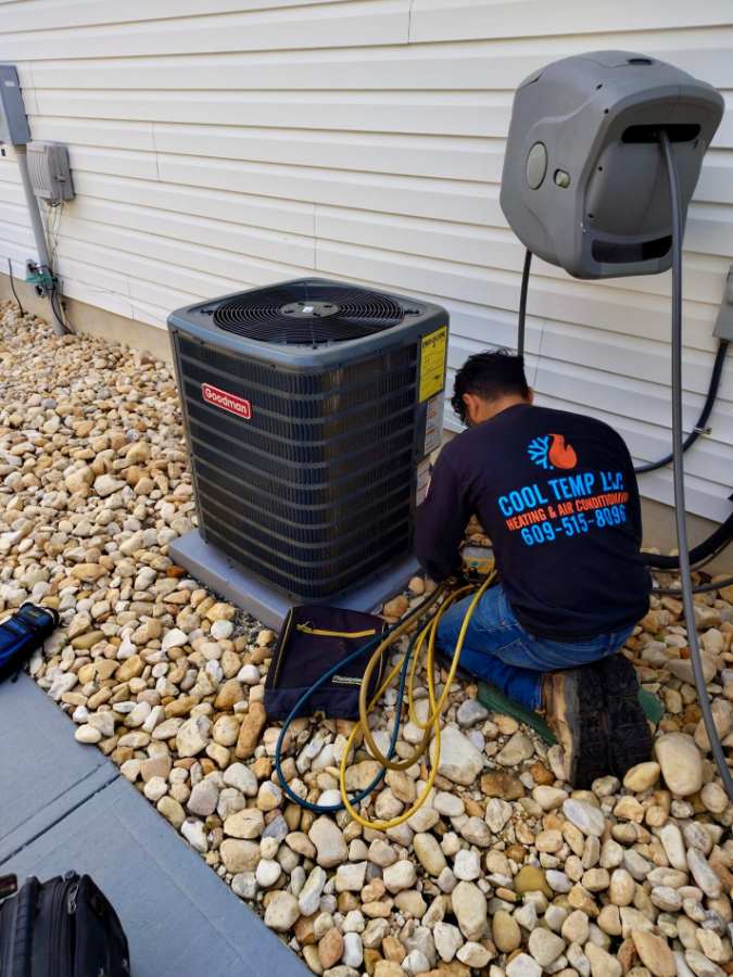 Cool Temp technician working on a condenser set in river rock